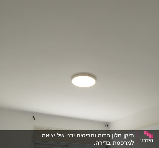 תריסים לבנים סגורים בחלון עם מסגרת לבנה